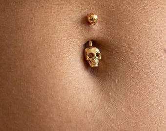 Navelpiercing met doodskopmotief in zilver of goud, minimalistische navelpiercing met doodskopmotief, gotische navelpiercing, stoere body jewellery