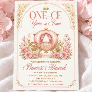 Könnte beinhalten: Eine rechteckige Einladungskarte mit einer rosa Kutschenillustration, goldener Krone und Blumenakzenten. Der Text lautet: ONE-CE Upon a Time, PLEASE JOIN US TO CELEBRATE Princess Ahuvah HER FIRST BIRTHDAY SUNDAY, MAY 16, 2027 2:00 PM THE ROSE GARDEN 123 BLOSSOM LANE, LOS ANGELES RSVP TO MOM BY MAY 2 310-555-0148.