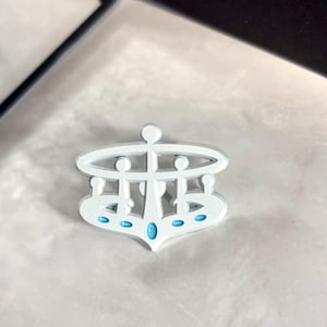 May include: White metal crown with a blue gem in the center and five smaller blue gems around the base.