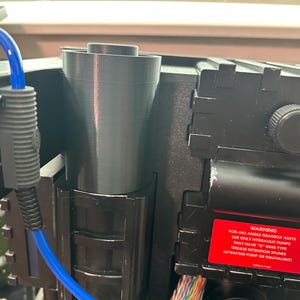 Op de afbeelding: Close-up van een zwarte hydraulische versnellingsbak met een waarschuwingsetiket met de tekst: "WAARSCHUWING FOR-DES ANGLE GEARBOX ASSYS ALLEEN HYDRAULISCHE POMPEN GEBRUIKEN DIE "O"-RING-TYPE VETTERUGHOUDEND SPUNES SPHATER PUMP OF EQUIVALENT HEBBEN"