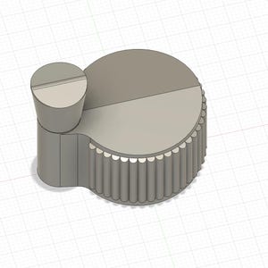 May include: A light gray, 3D-rendered knob with a cylindrical base and a circular top. The top is divided into two sections. A smaller, cylindrical piece with a slot is attached to the side. The edge of the knob has a scalloped design.