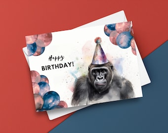 May include: A watercolor illustration of a gorilla wearing a colorful party hat with the words "Happy Birthday!" printed on the card. The background features watercolor splatters and blue and pink balloons.