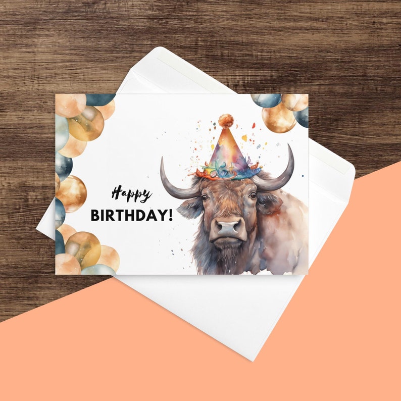 May include: A watercolor illustration of a brown bull wearing a colorful party hat with the text "Happy Birthday!" on a white background with gold and blue balloons.