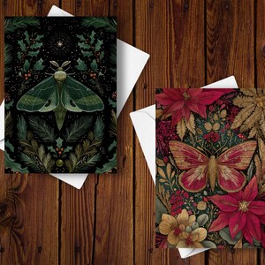 May include: Two greeting cards with nature-themed illustrations. One features a green moth with a dark background of holly and pine. The other card displays a red and gold butterfly surrounded by poinsettias and foliage. Both cards are on white envelopes.