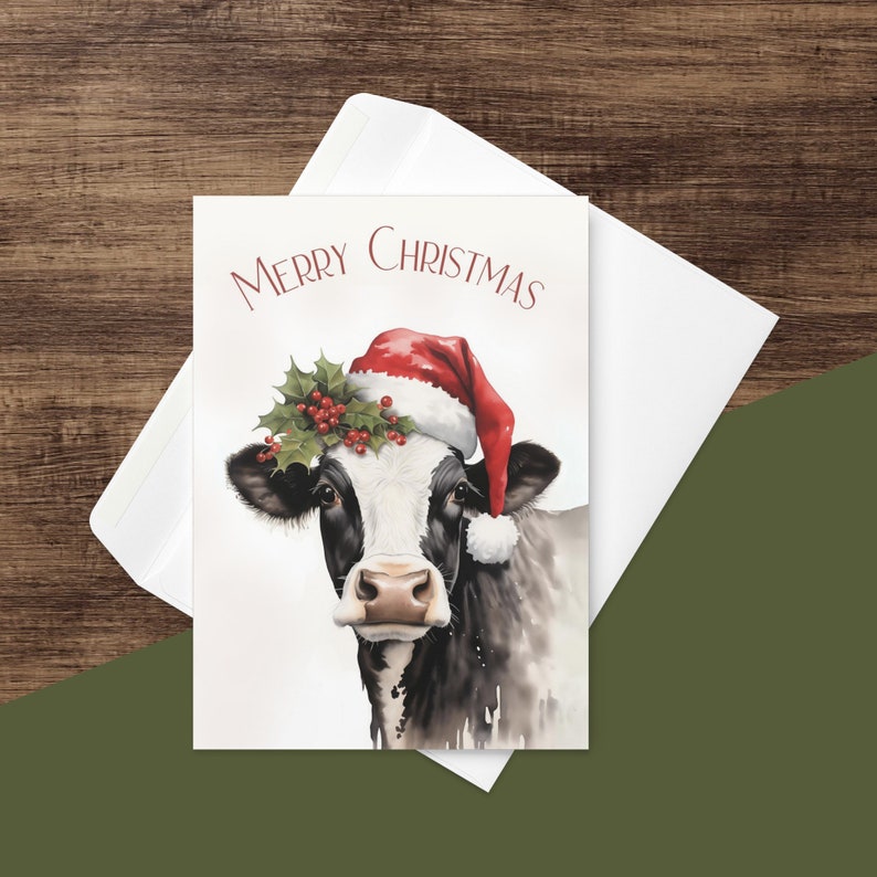 May include: A Christmas card featuring a black and white cow wearing a red Santa hat and a holly wreath. The card reads "Merry Christmas".