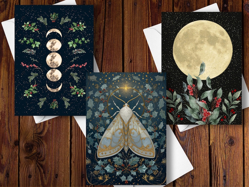 May include: Three art prints on white envelopes. One features moon phases and botanical elements on a dark blue background. Another showcases a moth with gold accents and botanical details. The third print displays a full moon with greenery and berries.