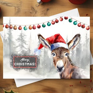Esel Weihnachtskarte, frohe Weihnachten Esel, der einen Weihnachtshut in einem schneebedeckten Winterszenen-Bauernhof-Tierfeiertagsgeschenk, Aquarell-Illustration trägt