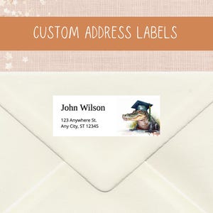 Op de afbeelding: Aangepaste adreslabels met een aquarel illustratie van een alligator met een afstudeerhoed. De labels bevatten een naam en adres, perfect voor afstudeeraankondigingen. De tekst "CUSTOM ADDRESS LABELS" wordt hierboven weergegeven.