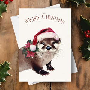 カワウソのクリスマス カード、サンタの帽子と赤いポインセチアのガーランドを身に着けている、かわいいカワウソの野生動物のホリデー ギフト、水彩画のイラスト