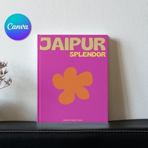 Può includere: Un libro rosa con il titolo "JAIPUR SPLENDOR" in testo giallo. Un grande fiore arancione è al centro della copertina. Il libro è su una superficie nera.