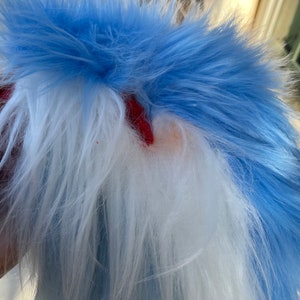 Puede incluir: Una cola de piel sint&eacute;tica azul y blanca esponjosa. La cola est&aacute; hecha de tela suave y afelpada y tiene un dise&ntilde;o largo y fluido.