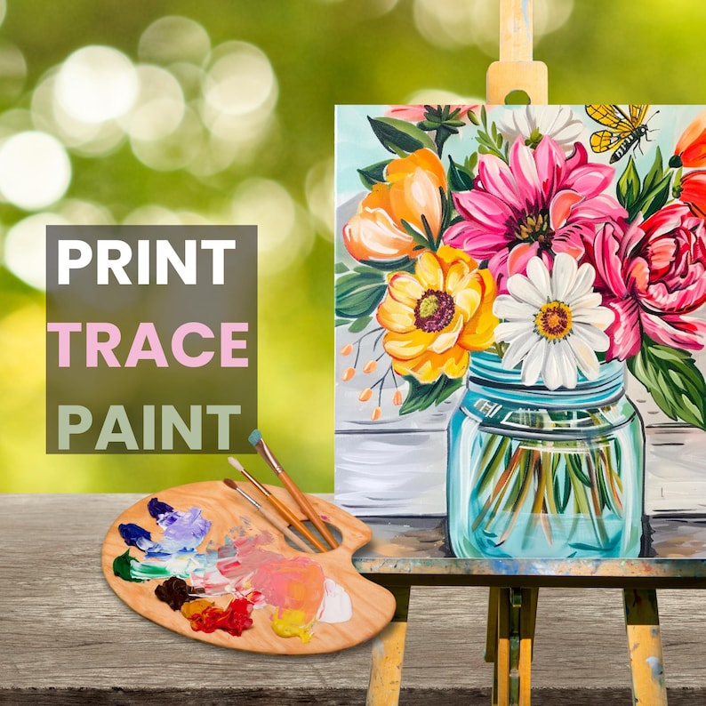 May include: A painting of a bouquet of flowers in a mason jar. The flowers are pink, yellow, and white. The painting is on a canvas and is on an easel. The words "PRINT TRACE PAINT" are written on a pink and white sign.