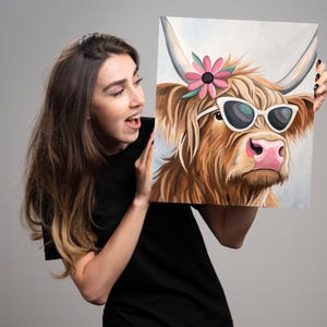 May include: A painting of a Highland cow wearing pink sunglasses and a pink flower. The cow has brown fur and a pink nose.