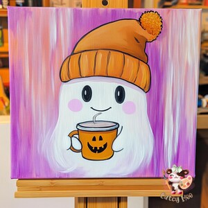 May include: A white ghost wearing an orange and brown knit hat with a white pom pom, holding a pumpkin-shaped mug with a steaming beverage. The background is a purple and pink ombre with white streaks.