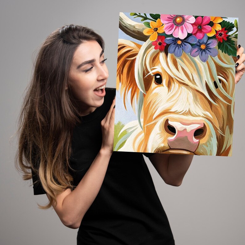 May include: A painting of a Highland cow wearing a flower crown. The cow has a light brown coat and a pink nose. The flowers in the crown are pink, purple, yellow, and orange.
