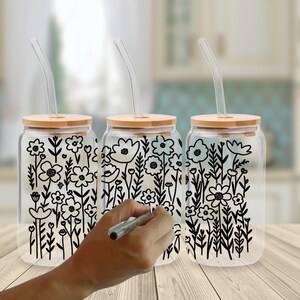 May include: Three clear glass jars with bamboo lids and black floral designs. Each jar has a clear plastic straw.