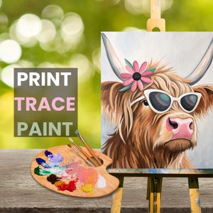 May include: A painting of a Highland cow wearing sunglasses and a flower crown. The painting is on a wooden easel with a paint palette and brushes in front of it. The text "PRINT TRACE PAINT" is visible in the image.