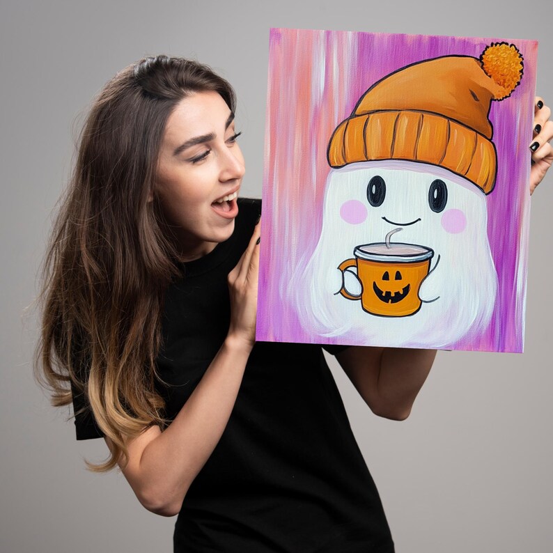 May include: A white ghost wearing an orange knit hat with a white pom pom holds a pumpkin-shaped mug with a steaming beverage. The ghost has a smiling face with rosy cheeks. The background is a purple and pink ombre.