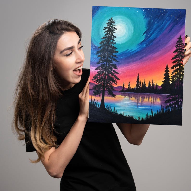 K&ouml;nnte beinhalten: Eine Frau h&auml;lt ein Gem&auml;lde mit einem farbenfrohen Sonnenuntergang &uuml;ber einem See mit einer Silhouette von B&auml;umen und einem Vollmond am Himmel.