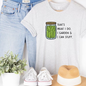 May include: A gray t-shirt with a graphic of a jar of pickles and the text "That's what I do. I garden & I can stuff."
