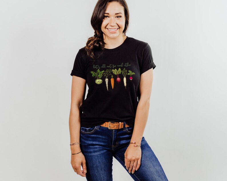 May include: Black t-shirt with a graphic of vegetables and the text "Let's all root for each other".