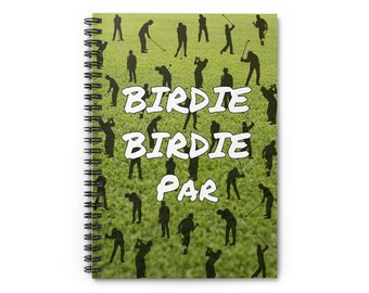 May include: A green and white spiral notebook with a golf theme. The cover features a green grass background with silhouettes of golfers and the text "Birdie Birdie Par".