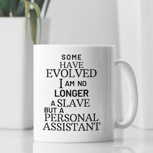 May include: White ceramic coffee mug with black text that reads "Some have evolved I am no longer a slave but a personal assistant".