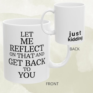 May include: White ceramic mug with the text "LET ME REFLECT ON THAT AND GET BACK TO YOU" on the front and "just kidding" on the back. The mug has a curved handle and is set against a soft, watercolor-style background.