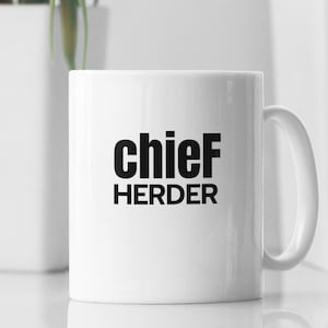 May include: White ceramic mug with black text that reads "chief HERDER".