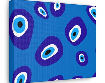Puede incluir: Una impresión en lienzo azul con un patrón de ojos malos blancos, azules y negros. Los ojos malos están dispuestos en un patrón aleatorio sobre un fondo azul.