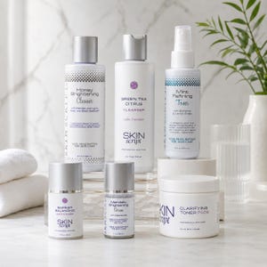 May include: A collection of white skincare products with silver caps and labels. The products include cleansers, toners, and moisturizers. The brand name "Skin Script" is visible on several items. The products are arranged on a white surface.