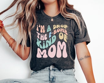 May include: A gray t-shirt with the text "I'm a drop the f-bomb kind of mom" in colorful, retro-style lettering.