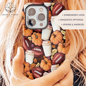 May include: A phone case with an embroidered design featuring pumpkins, coffee cups, and footballs. The text "EMBROIDERY LOOK", "MAGSAFE® OPTIONAL", and "IPHONE & ANDROID" is visible on the case.