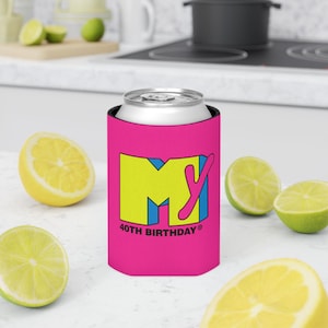 May include: A pink can cooler with the MTV logo in yellow, blue, and pink. The text "40TH BIRTHDAY" is printed below the logo. The cooler is holding a silver can, with lemon and lime slices in the background.
