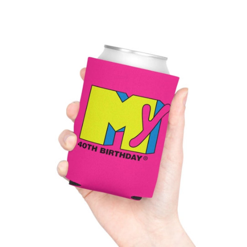 May include: A pink can cooler featuring the MTV logo in yellow, blue, and pink, with "40TH BIRTHDAY" printed below. The can cooler is designed to keep beverages cold and is held in a hand.