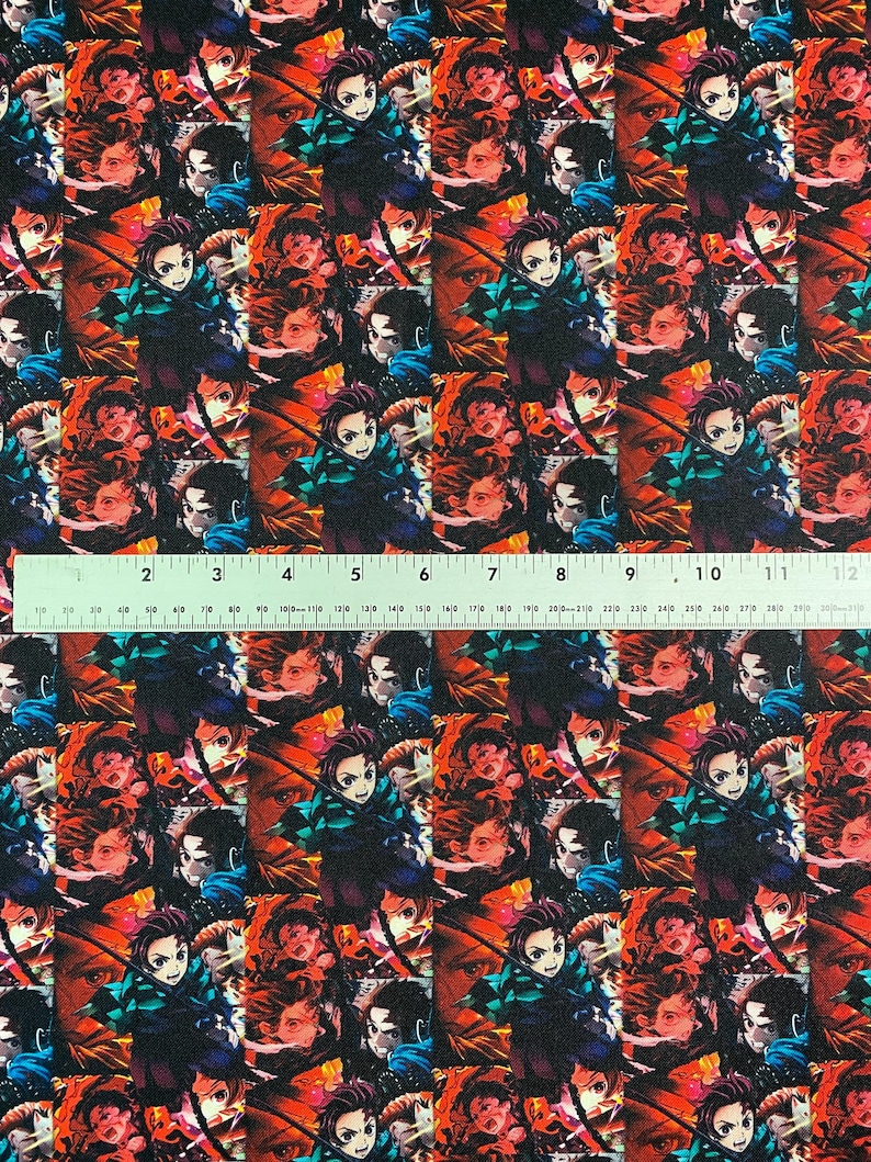 May include: Fabric with a repeating pattern of anime characters in various poses. The design features characters with dark hair, green and black outfits, and red and orange backgrounds. The ruler shows measurements in inches.