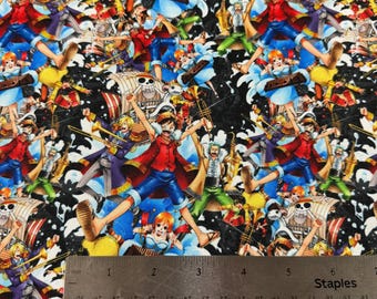 May include: Fabric with a colorful, repeating pattern featuring cartoon characters in action poses. The design includes figures in red, blue, and yellow, set against a black and white background. The image includes a ruler with inch measurements.