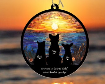 Könnte beinhalten: Ein runder Holzanhänger mit einer Buntglas-Sonnenuntergangsszene und drei Silhouetten von Haustieren. Die Haustiere sind eine Katze und zwei Hunde. Der Text "YOU WERE MY favorite 'hello' AND MY hardest 'goodbye'" ist unter den Silhouetten gedruckt. Der Anhänger ist ein Denkmal für Haustiere.