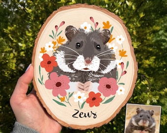 May include: A wooden slice featuring a hand-painted hamster portrait surrounded by colorful flowers. The hamster is gray and white, with the name "Zeus" written below. A smaller photo of the hamster is in the lower right corner.