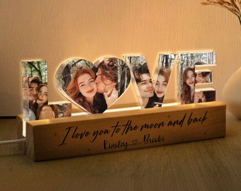 May include: A wooden light-up sign with the word "LOVE" spelled out in clear acrylic letters. Each letter has a photo of a couple inside. The base of the sign has the text "I love you to the moon and back" and "Kinsley Brooks".