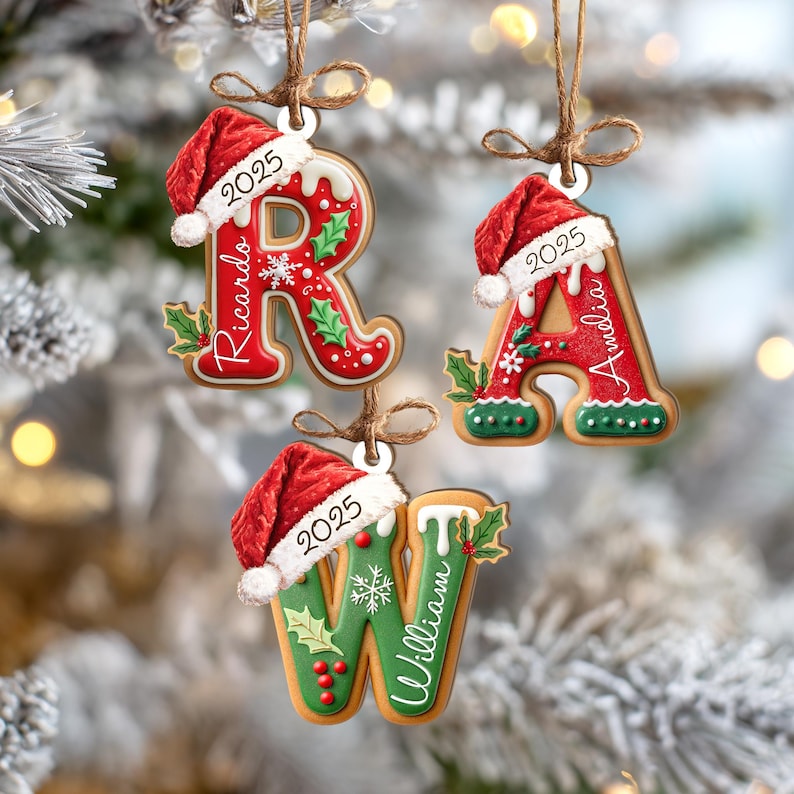 Pu&ograve; includere: Addobbi natalizi a forma di lettere di pan di zenzero, ognuno ornato da un cappello di Babbo Natale e l'anno 2025. Le lettere sono rosse e verdi, con nomi come "Ricardo", "Amelia" e "William". Appesi con spago.