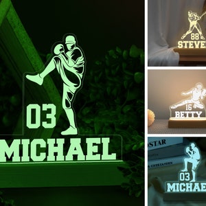 May include: A green illuminated acrylic night light with a baseball player silhouette, the number "03" and the name "MICHAEL" on a wooden base.