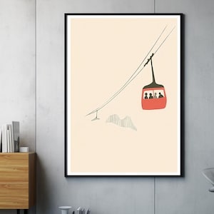 Könnte beinhalten: Ein gerahmter Kunstdruck mit einer minimalistischen Illustration einer roten Seilbahnkabine, die an einem Seil hängt. Die Kabine befördert drei Passagiere. Darunter ist eine Bergkette in Schwarz auf cremefarbenem Hintergrund skizziert.