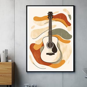 May include: Abstract art print featuring a brown acoustic guitar with a white body and brown strings. The guitar is set against a background of abstract shapes in shades of orange, brown, and green.