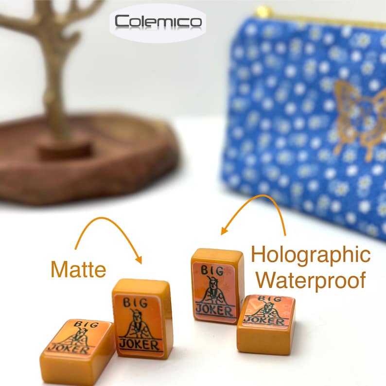 May include: Four orange and tan "Big Joker" tiles with a graphic of a person. The tiles are matte and waterproof. A blue floral pouch with a gold butterfly design is in the background.