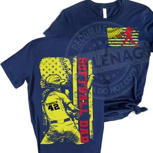 May include: Navy blue t-shirt with a yellow and red graphic of a softball player with the text "Softball Dad" and "Emily 42".