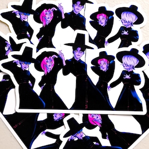 Puede incluir: Un conjunto de pegatinas con ilustraciones de figuras vestidas de negro y con sombreros de ala ancha. Las figuras tienen diferentes colores de pelo, incluyendo rosa, azul y blanco. Las pegatinas tienen un borde blanco y están dispuestas de forma ligeramente superpuesta.