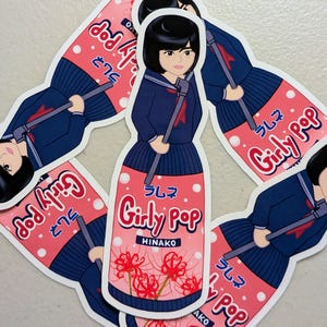 May include: A collection of stickers featuring a cartoon girl in a navy blue school uniform holding a stick. The stickers are shaped like a bottle with the words "Girly Pop" and Japanese text. The bottle design includes red flowers and the name "HINAKO".