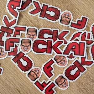 May include: A collection of die-cut stickers featuring the red pixelated text FUCKAI and a small, repeating pixel-art portrait of a person with a wide, toothy grin. The stickers are arranged in a scattered pattern, showcasing the bold red font.