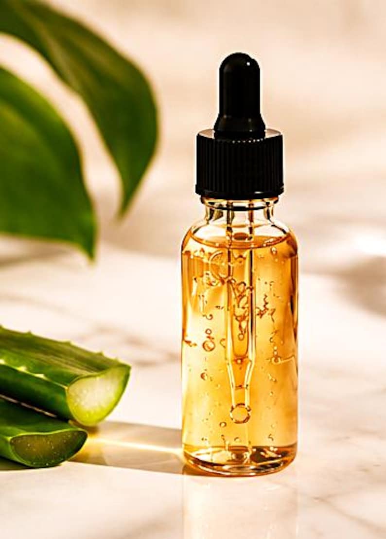 K&ouml;nnte beinhalten: Eine klare Glastropfflasche gef&uuml;llt mit einem goldfarbenen fl&uuml;ssigen Serum. Die Flasche verf&uuml;gt &uuml;ber einen schwarzen Schraubverschluss mit integrierter Glastropfpipette. Die Fl&uuml;ssigkeit im Inneren ist durchscheinend und enth&auml;lt kleine Luftblasen.